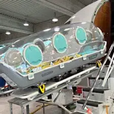 Isolation containment unit being loaded onto a fixed wing aircraft